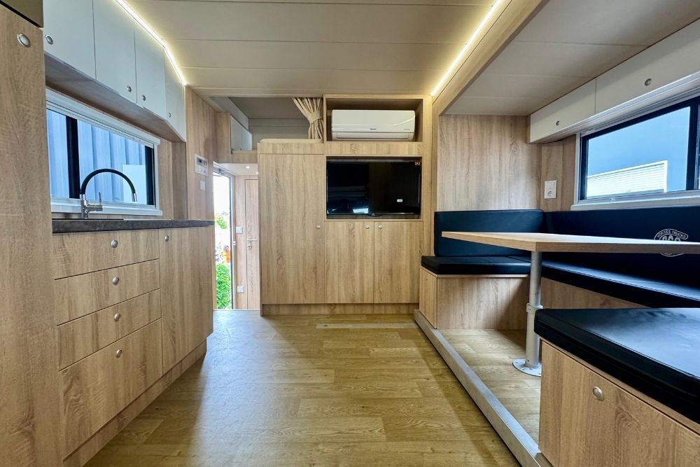 Intérieur bois d’un camion chevaux pl conceptpgo: kitchenette, rangements et coin repas avec banquettes.