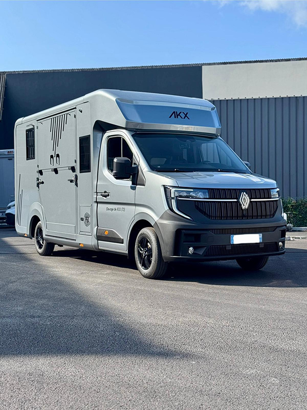 Camion chevaux VL AKX gris, stationné devant un bâtiment conceptpgo.